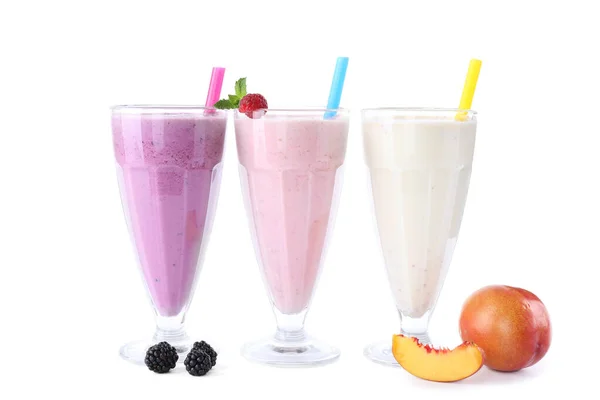 Different fresh tasty milk shakes in glasses with ingredients on white background — Stock Photo, Image