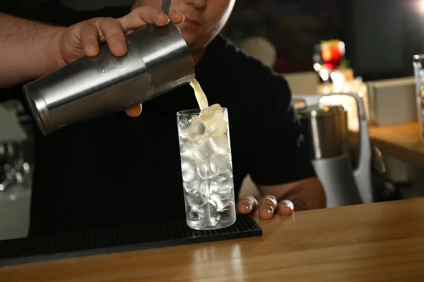 Barman fazendo delicioso coquetel com vodka no balcão de madeira no bar, close-up — Fotografia de Stock