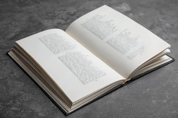 Nyílt keménykötésű könyv szürke kőasztalról — Stock Fotó