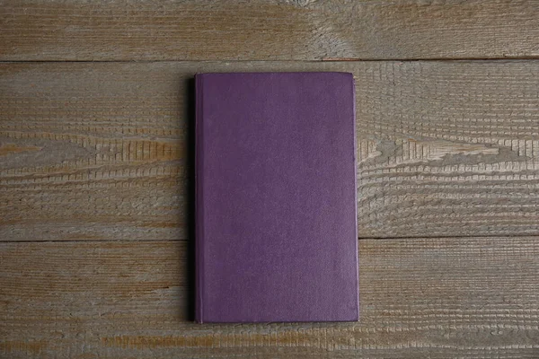 Twarda książka na drewnianym stole, widok z góry. Miejsce na tekst — Zdjęcie stockowe