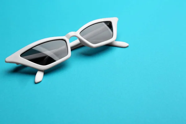 Óculos de sol elegantes em fundo azul, espaço para texto. Acessório na moda — Fotografia de Stock