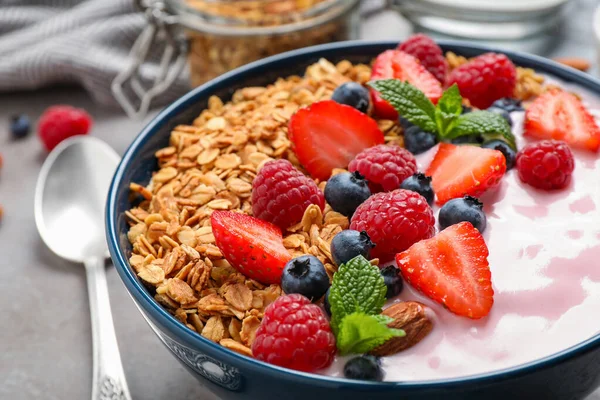 Smaklig hemlagad granola med yoghurt på grått bord, närbild. Sund frukost — Stockfoto