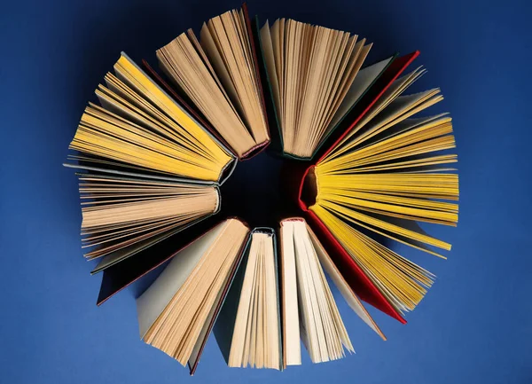 Círculo feito de livros de capa dura sobre fundo azul, flat lay — Fotografia de Stock
