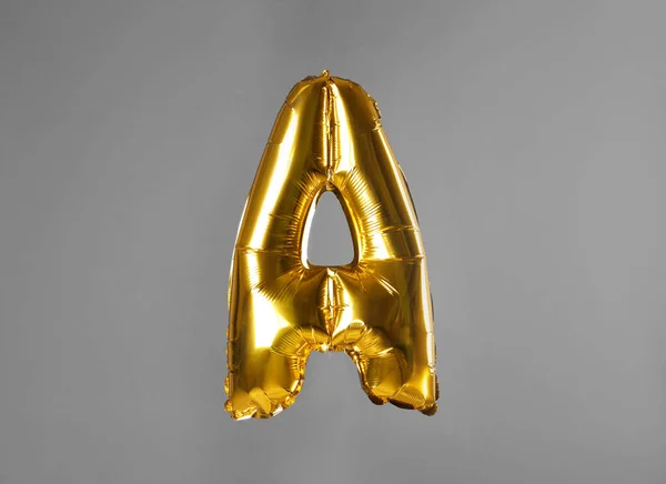 Golden letter A balloon on grey background — Stock Photo, Image