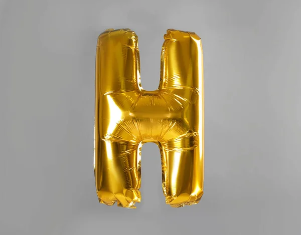 Globo dorada letra H sobre fondo gris — Foto de Stock