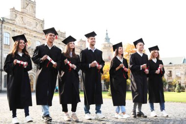 Açık havada diplomalı mutlu öğrenciler. Mezuniyet töreni