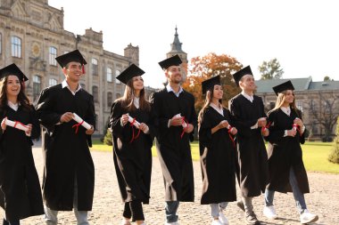 Açık havada diplomalı mutlu öğrenciler. Mezuniyet töreni