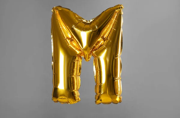 Letra dorada M globo sobre fondo gris — Foto de Stock