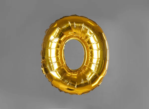 Golden letter O balloon on grey background