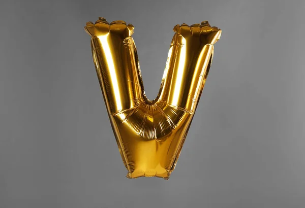 Golden letter V balloon on grey background — Stock Photo, Image
