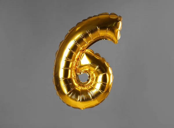 Zlatý balón číslo šest na šedém pozadí — Stock fotografie