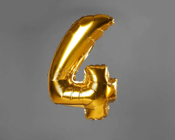 Golden number four balloon on grey background — ストック写真