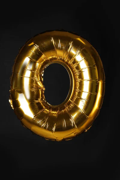 Golden letter O balloon on black background — ストック写真