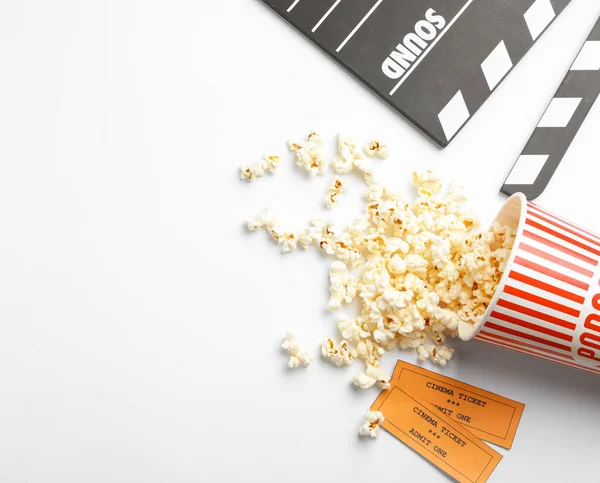 Lavagna, popcorn e biglietti su sfondo bianco, vista dall'alto. Spuntino cinematografico — Foto Stock