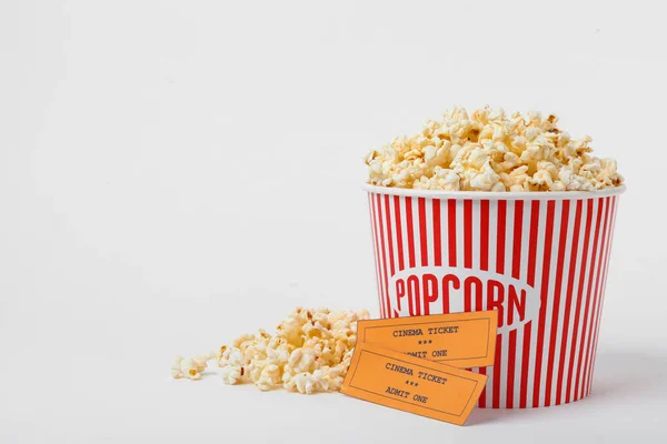 Eimer mit frischem Popcorn und Tickets auf weißem Hintergrund. Kinosnack — Stockfoto