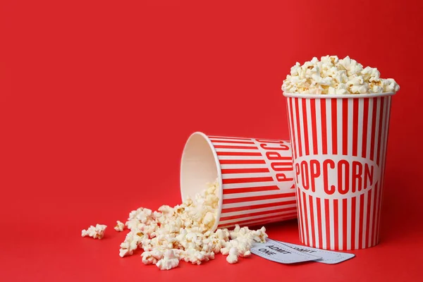 Popcorn and tickets on red background, space for text. Cinema snack — Stock Photo, Image