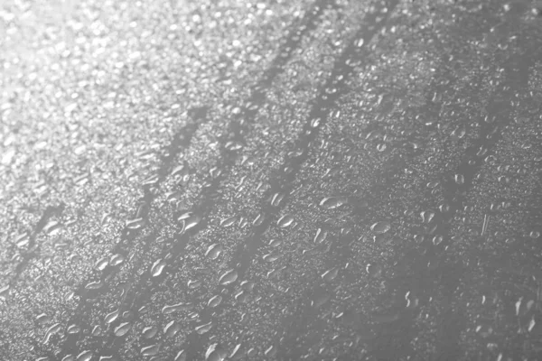 Vidro com gotas de chuva contra fundo claro — Fotografia de Stock