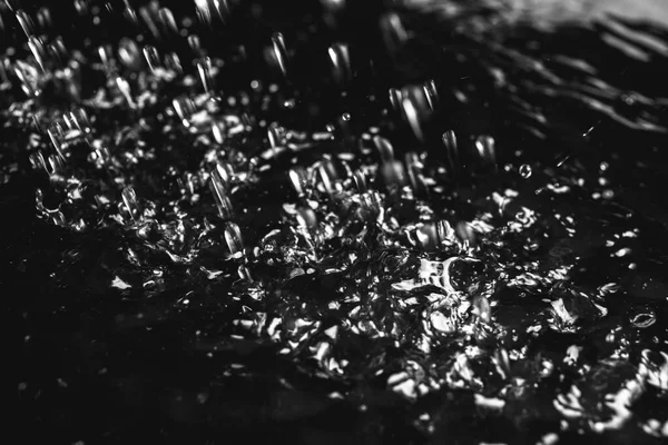 Сильний дощ падає на землю на темному тлі, крупним планом — стокове фото