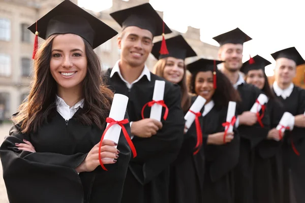 Estudantes felizes com diplomas ao ar livre. Cerimónia de graduação — Fotografia de Stock