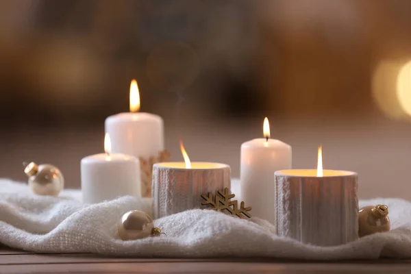Σύνθεση με κεριά σε περίτεχνη θήκη σε ξύλινο τραπέζι με φόντο θολή. Χριστουγεννιάτικη διακόσμηση — Φωτογραφία Αρχείου
