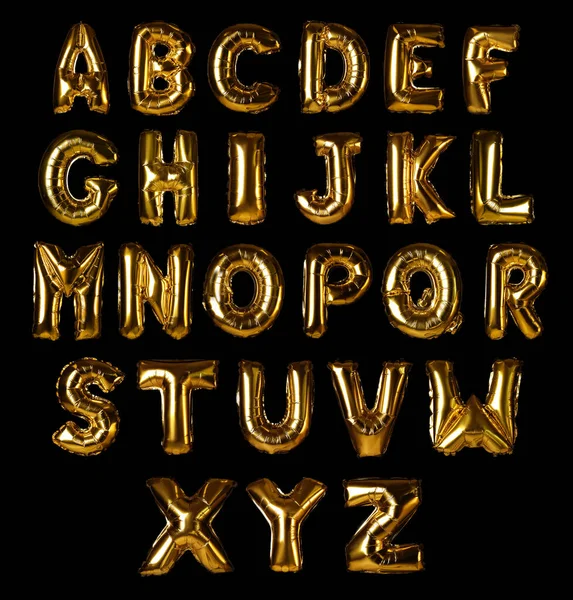 Set con palloncini di lamina d'oro a forma di lettere su sfondo nero — Foto Stock