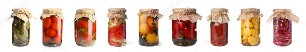 Set of glass jars with different pickled vegetables on white background