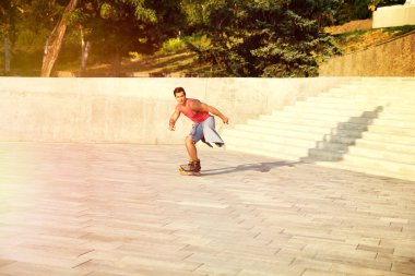 Yakışıklı genç adam paten açık havada paten. Eğlence aktivitesi