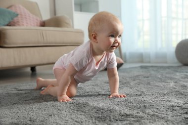 İçerideki yumuşak halıda sürünen tatlı küçük bebek.