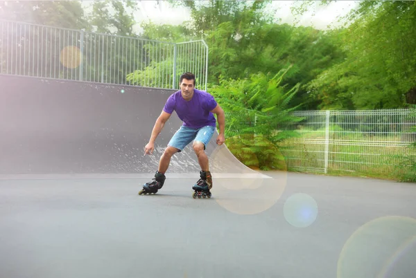 Handsome young man roller skating in park