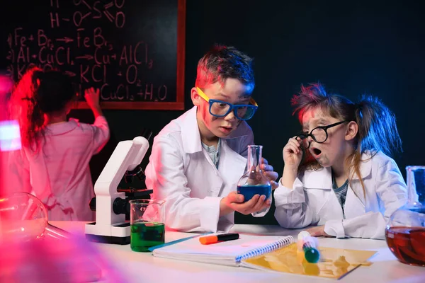 Barn som gör kemisk forskning i laboratorium. Farligt experiment — Stockfoto