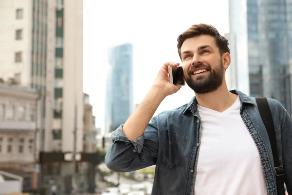 Bonito homem falando ao telefone na cidade moderna — Fotografia de Stock