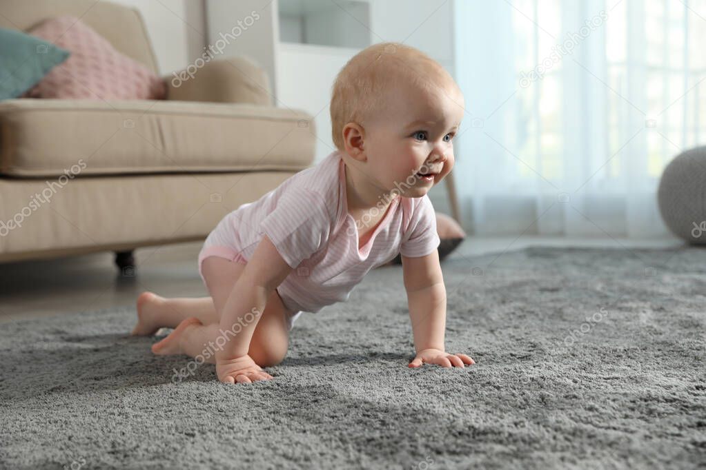 Cute little baby crawling on soft carpet indoors