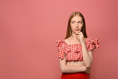 Pembe arka planda düşünceli genç bir kadının portresi, mesaj için yer.