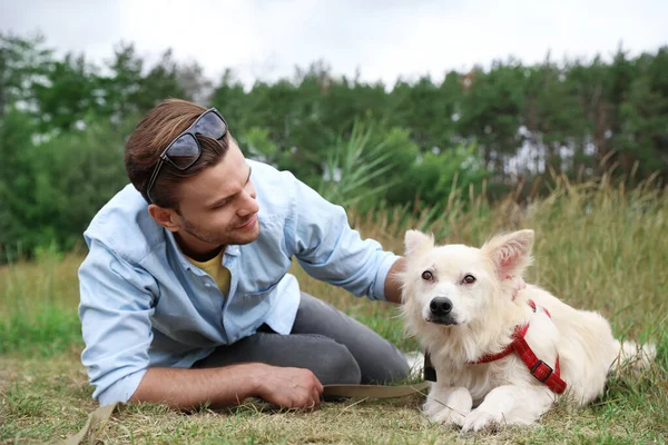 Volontaire masculin avec chien sans abri au refuge pour animaux à l'extérieur — Photo