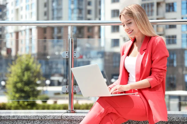 Hermosa mujer de negocios con portátil en la calle de la ciudad. Espacio para texto — Foto de Stock