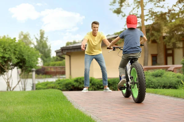 Papa enseigne à son fils à faire du vélo à l'extérieur — Photo