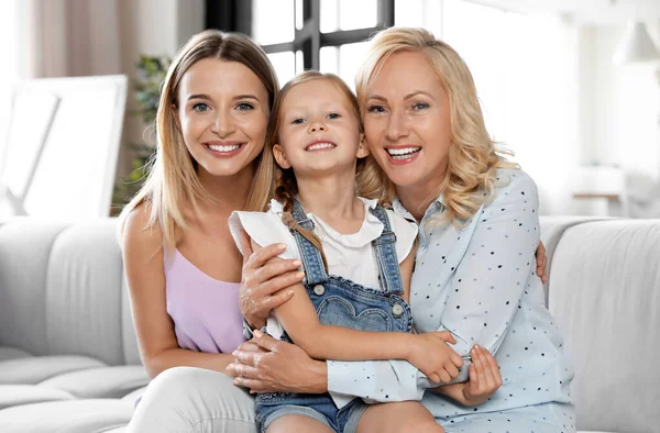 Young woman with mature mother and little daughter in living room — Stock Photo, Image