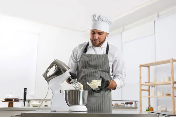 Chef de pastelaria masculino preparando massa em misturador na mesa da cozinha — Fotografia de Stock