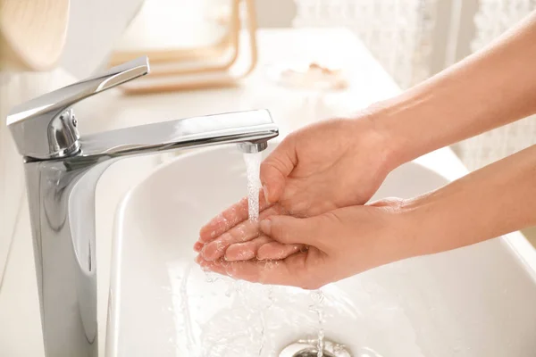 Wanita muda mencuci tangan di atas wastafel di kamar mandi, menutup — Stok Foto