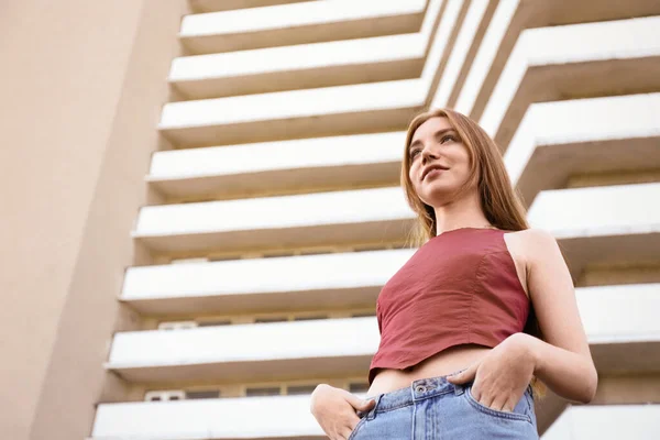 Piękna młoda kobieta w nowoczesnym budynku, niski kąt widzenia — Zdjęcie stockowe