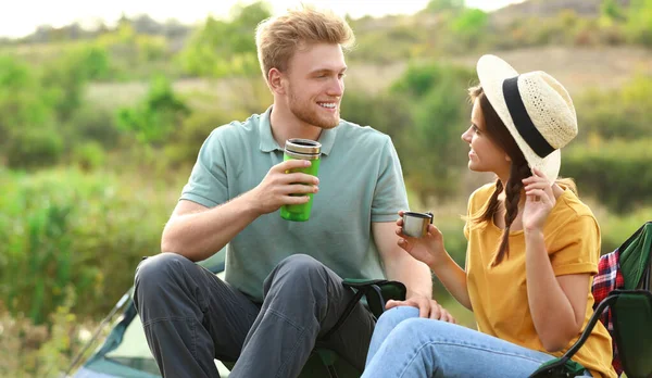 Giovane coppia con bevande calde a riposo all'aperto. Vacanze in campeggio — Foto Stock