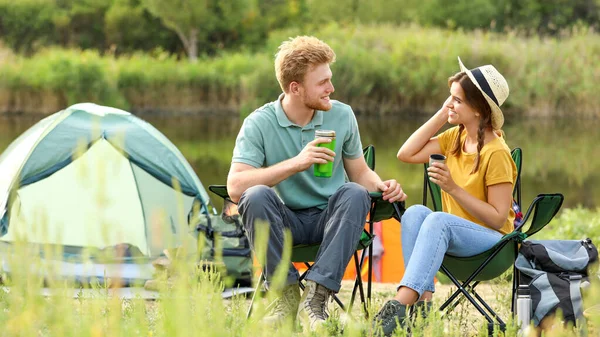 Unga par med varma drycker som vilar utomhus. Camping semester — Stockfoto