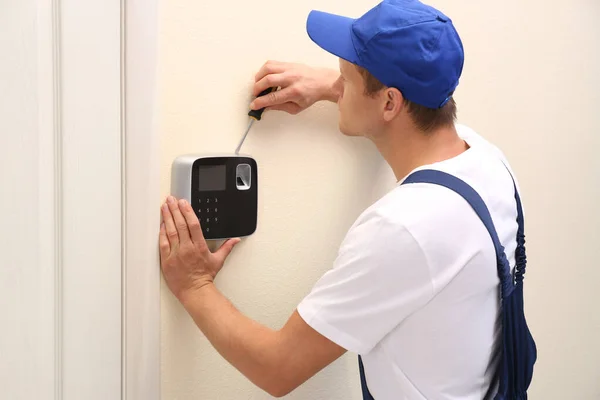 Técnico masculino instalando sistema de alarma de seguridad en interiores —  Fotos de Stock