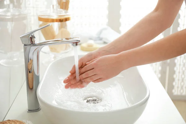 Mulher a lavar as mãos dentro de casa, de perto. Interior do banheiro — Fotografia de Stock