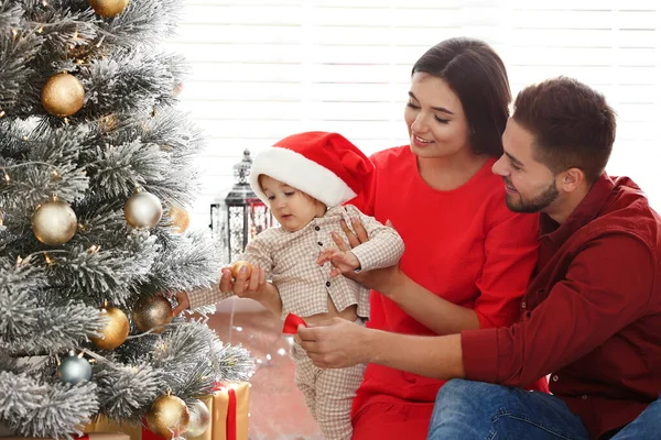 Familia feliz con lindo bebé cerca del árbol de Navidad en casa —  Fotos de Stock