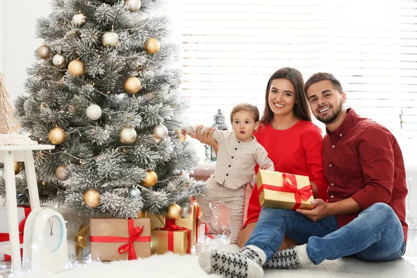 Familia feliz con lindo bebé cerca del árbol de Navidad en casa —  Fotos de Stock