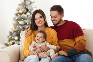 Evde şirin bir bebeği olan mutlu bir aile. Noel kutlaması