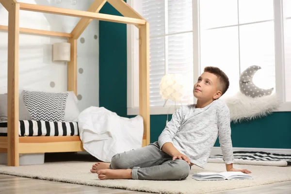 Niño pequeño con libro en el elegante interior del dormitorio — Foto de Stock