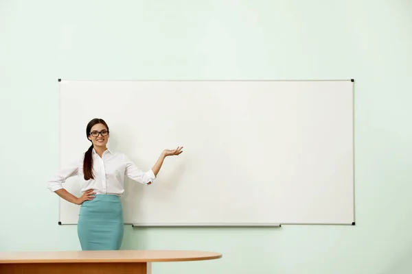 Modern sınıfta beyaz tahtanın yanında bayan öğretmen. — Stok fotoğraf