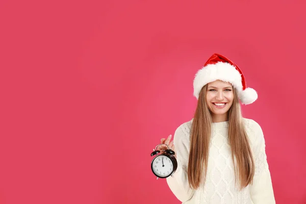 Joyeux jeune femme en chapeau de Père Noël avec réveil sur fond rose, espace pour le texte. Temps de Noël — Photo